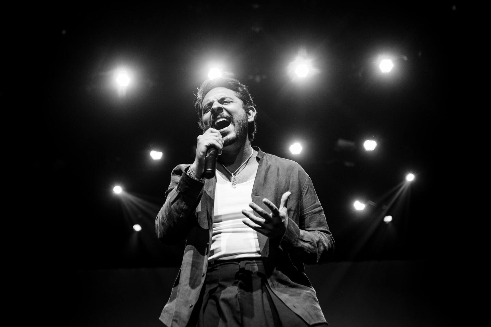 Pedro Parlo cantando en el escenario, en blanco y negro